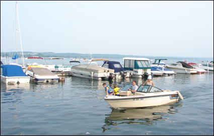 A family prepares to park their boat at a marina on Canandaigua Lake in the City of Canandaigua in the Finger Lakes, New York USA.